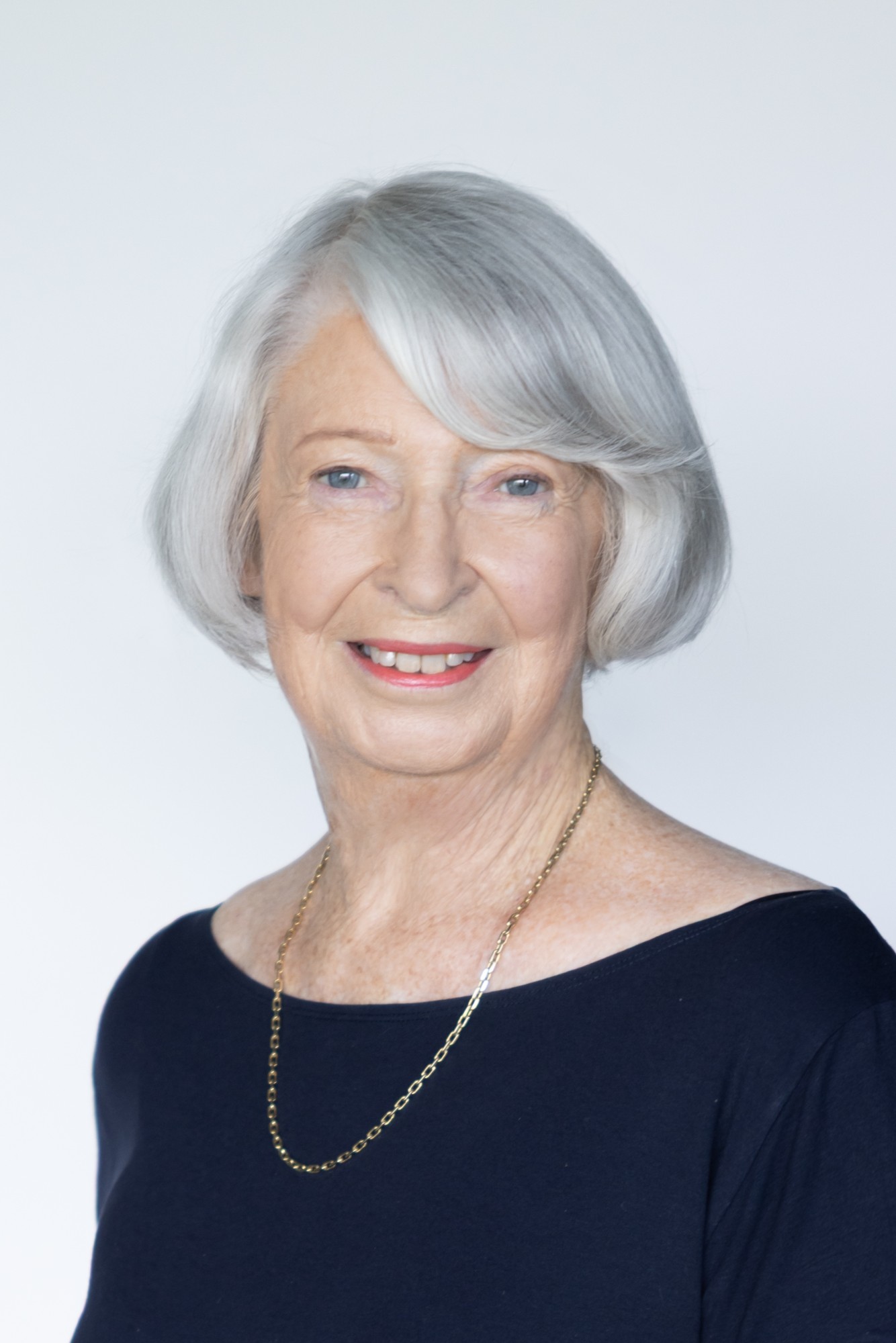 Nancy Crooks, smiling, with silver hair and a navy top