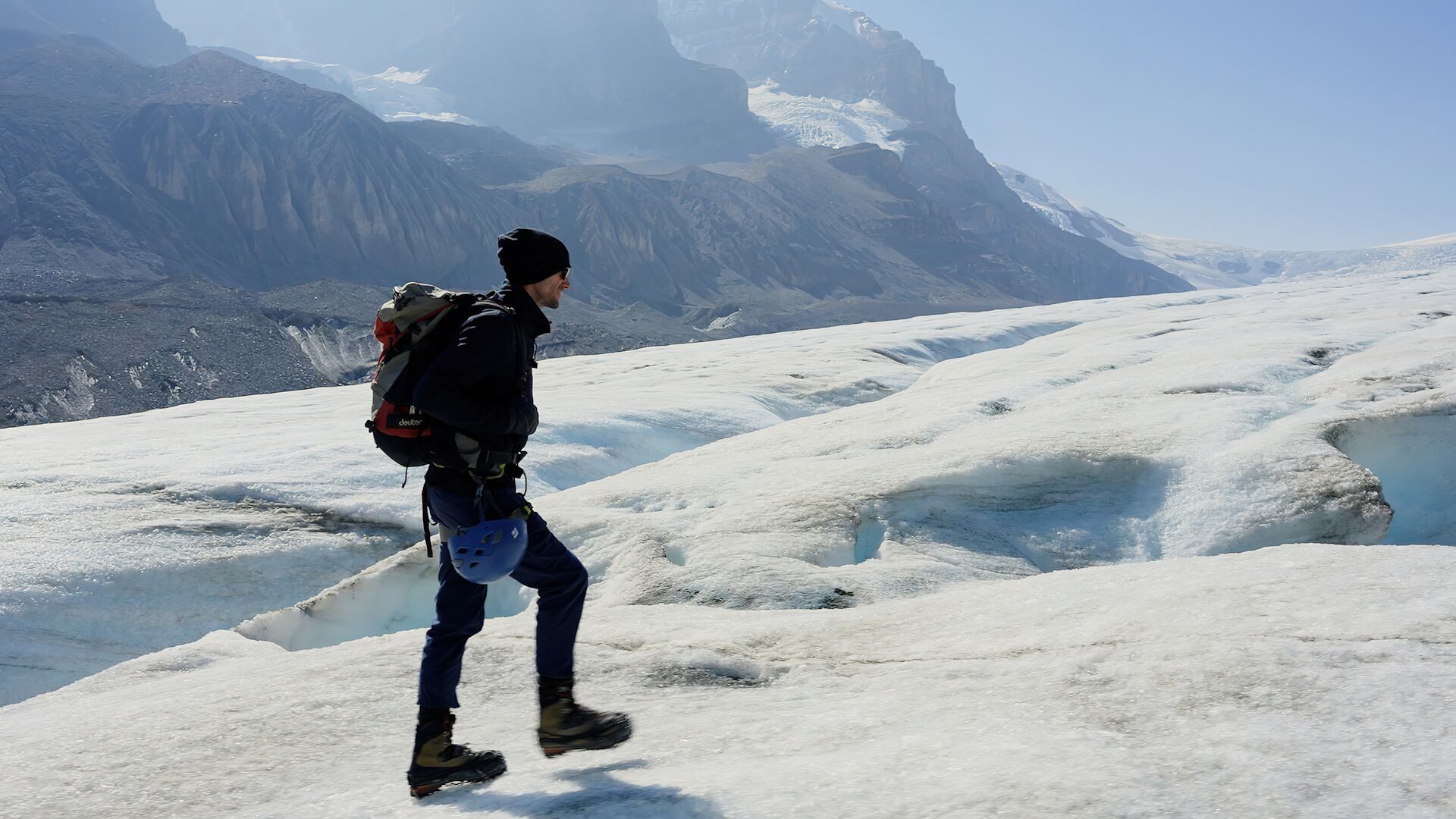 A hiker with a pack crossing the Athabasca Glacier