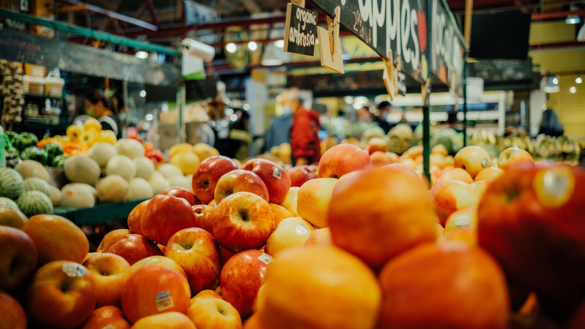 Stacks of fresh oranges and apples at a Granville Island market stall