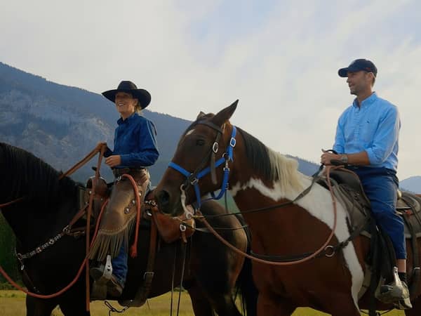 Two riders on horseback in the Banff foothills