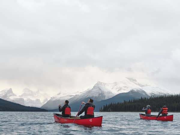 Red canoes on the still water of Maligne Lake