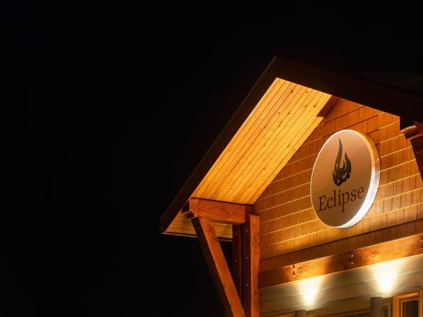 A timber lodge entrance glowing against the winter night