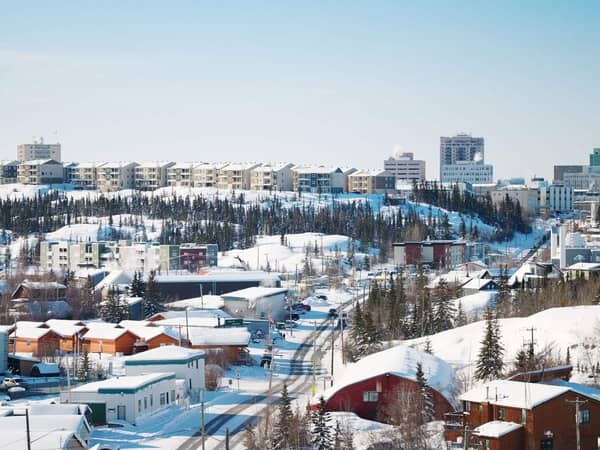 Snow-covered rooftops and the skyline of Yellowknife on a clear winter day