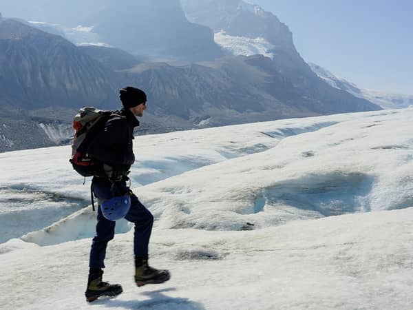 A hiker with a pack crossing the Athabasca Glacier